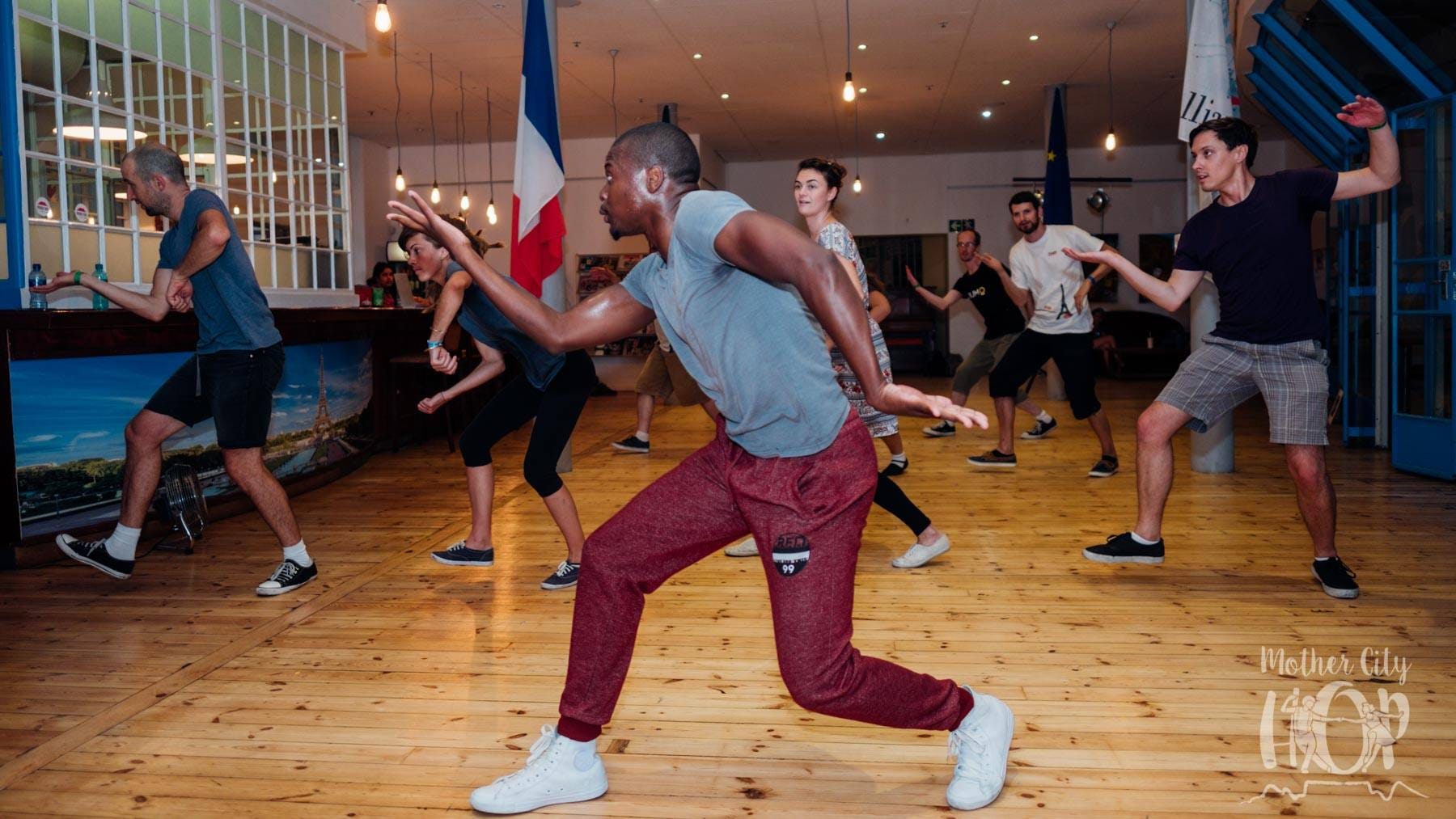 an image of a group of people in a routine and all dancing together with Elvis Sibeko in front and leading them