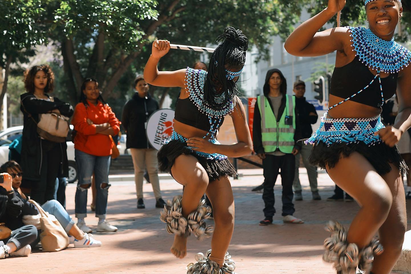 an image of you african females wearing african attire and dancing in the streets of teh CBD of Cape Town South Africa with a crowd watching them
