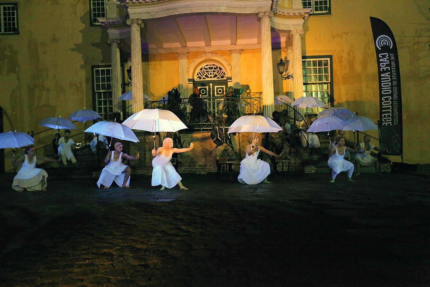 an image of a group of women dressed in white and holding white umbrellas on the stage performing at an african event in berlin