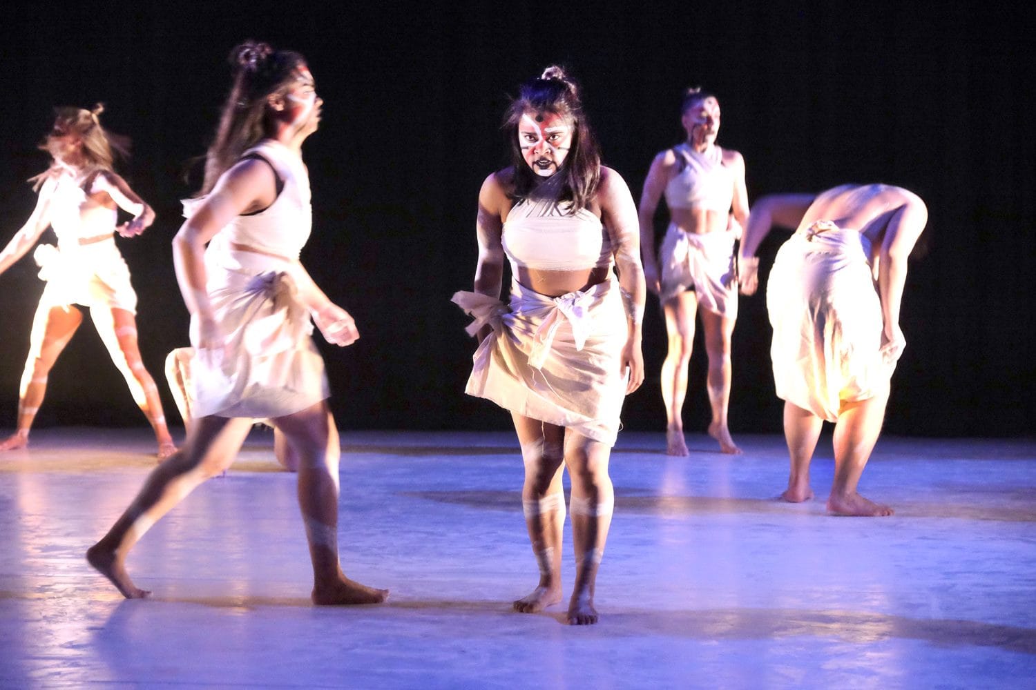 an image of a group of women dressed in white rags on the stage performing at an african event in berlin
